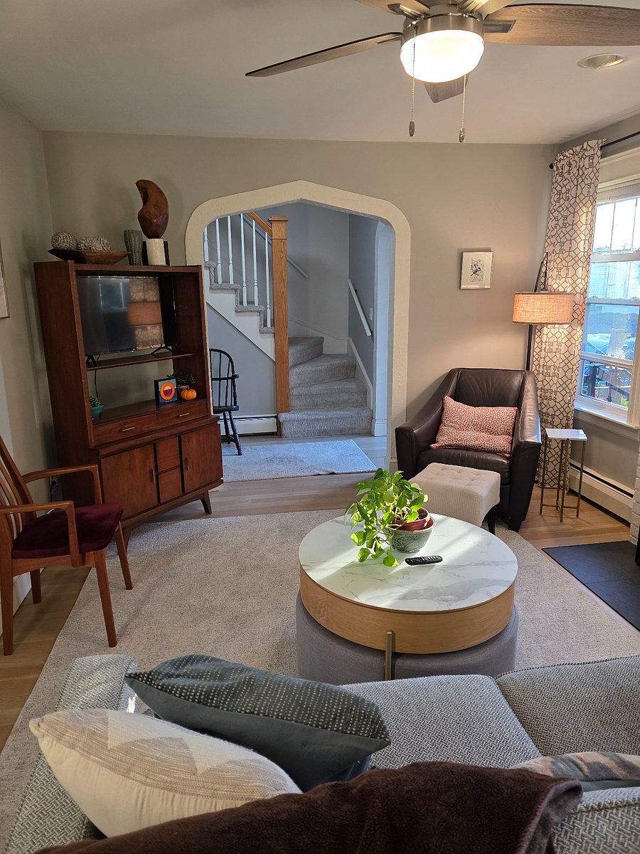 main living room with TV and view of stairs leading to second floor