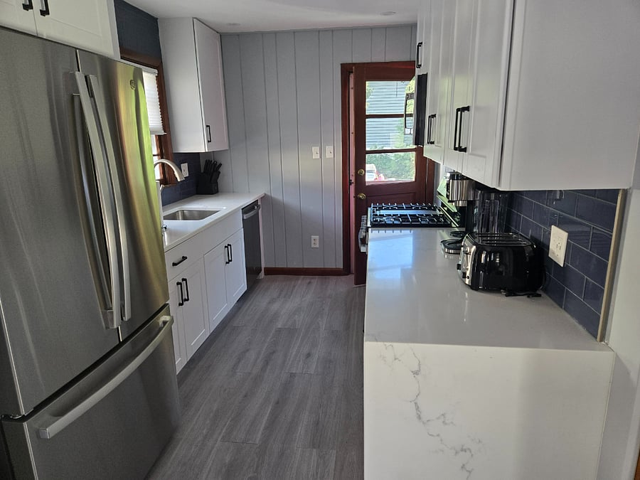 full kitchen with new cabinets, quartz counter with waterfall, and stainless steel appliances