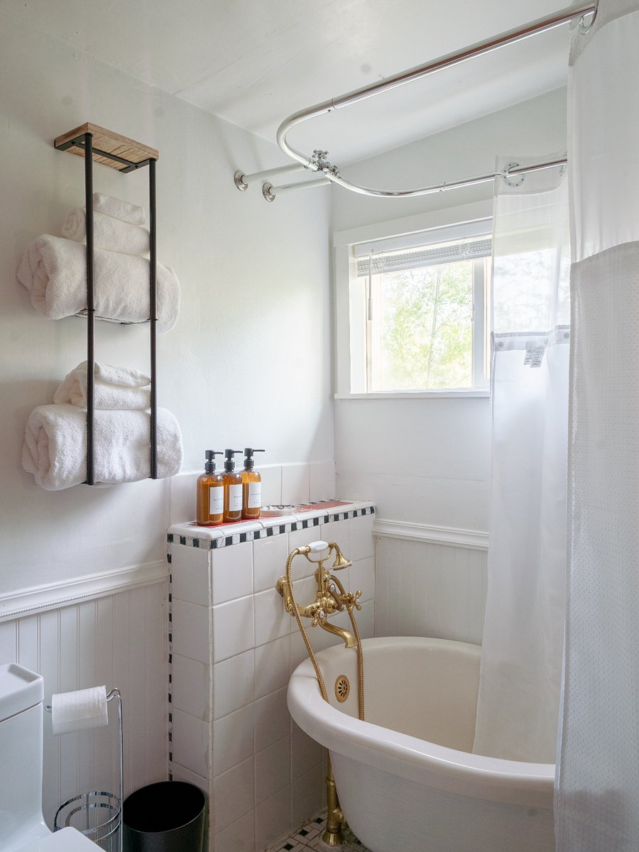 The bathroom has a clawfoot tub with a shower head, a new toilet, and a new sink.