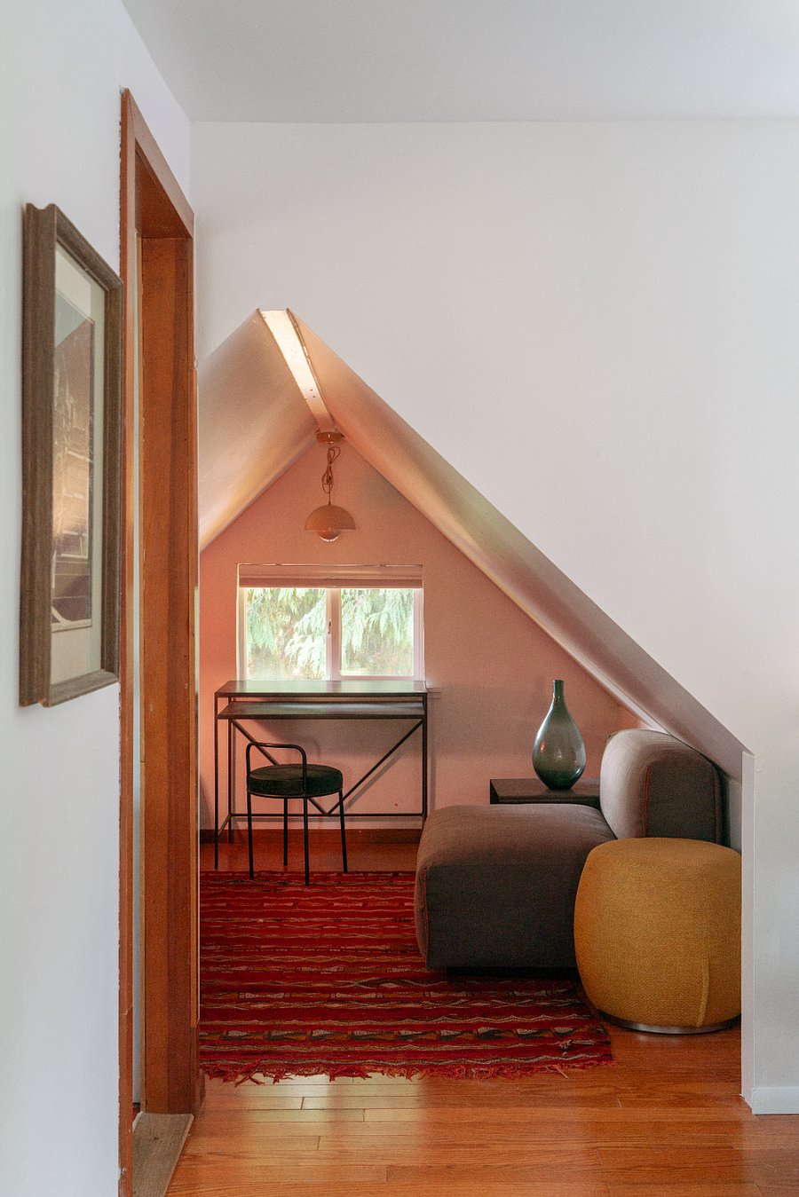 A dedicated workspace has a desk, dresser, and cozy chair for reading.