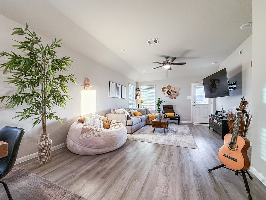Relaxing living room with a plush sectional, cozy seating, and a large Smart TV. A bright, comfortable space ideal for movie nights and downtime.
