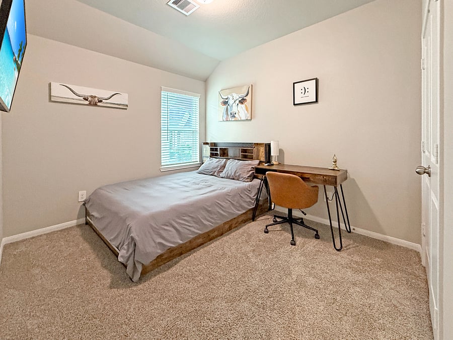 Cozy guest bedroom with a comfortable bed, Smart TV, and workspace. Perfect for remote work, teens, or long-term stays.