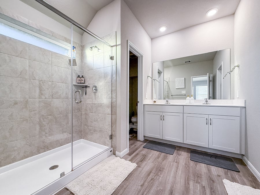 Modern bathroom with a large walk-in shower, double vanity, and bright lighting. A clean, spa-like space to refresh and unwind.