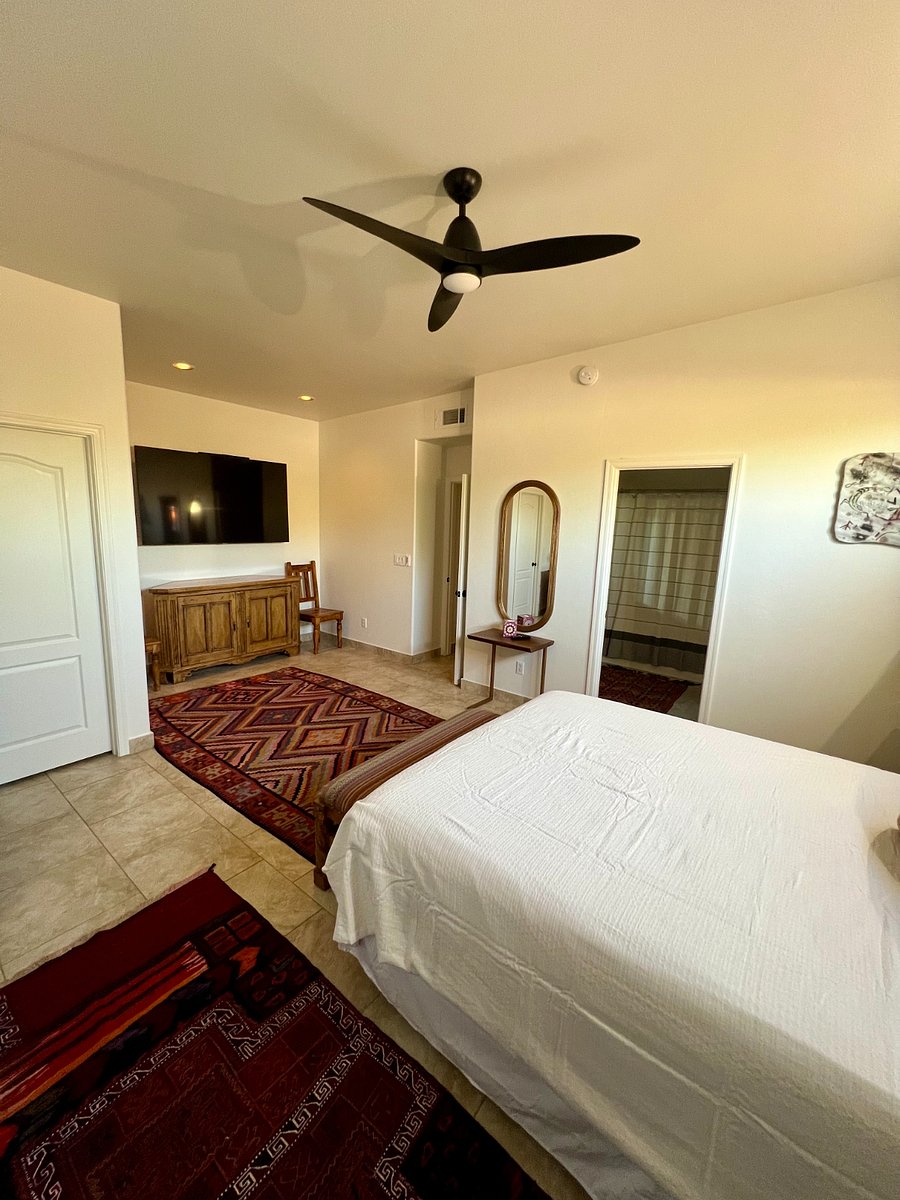 Primary bedroom showing 72 inch wide Samsung TV mounted on the wall 