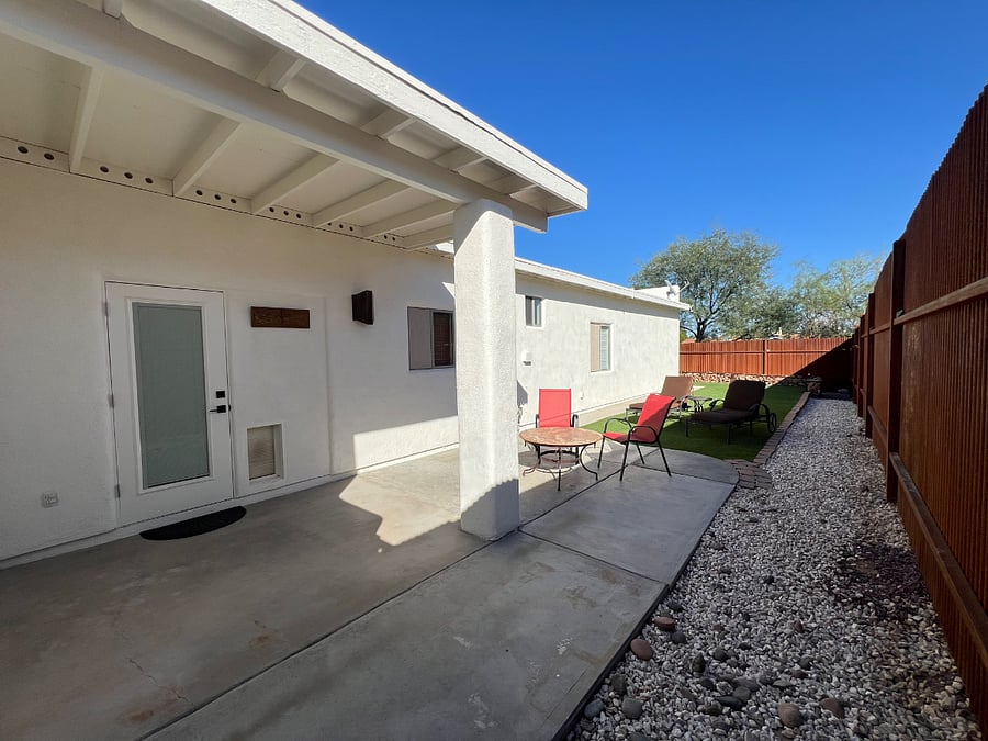 South side patio. Notice the 8 privacy fence that goes all the way around the back yard. You can see the doggie door to the lower right of the back door.