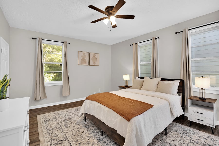 Peaceful master bedroom with queen bed, blackout curtains, and soft lighting perfect for rest after long shifts.