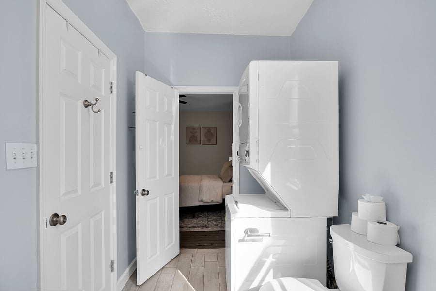 Modern bathroom with fresh towels, full shower, washer/dryer, and starter toiletries provided.