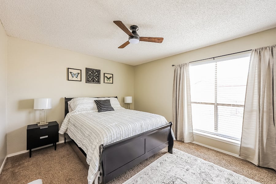 Primary bedroom with queen bed, blackout curtains, and ample closet space for extended stays.