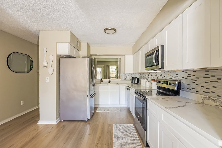 Kitchen view highlighting stove, microwave, and generous counter space for everyday cooking.