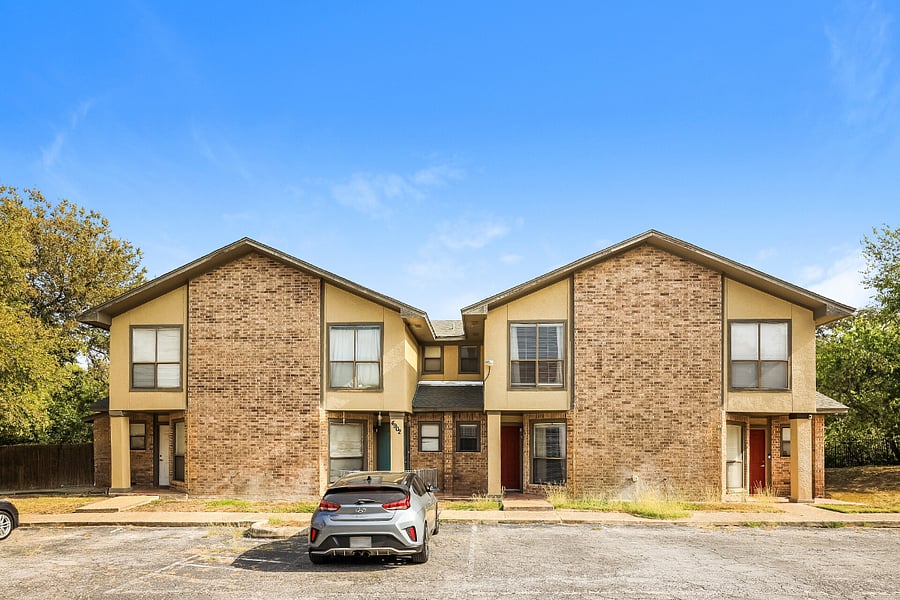 Front exterior of the property with designated off-street parking for the unit.