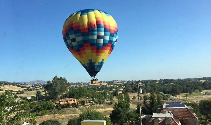 Hot air balloons traveling over this home.
