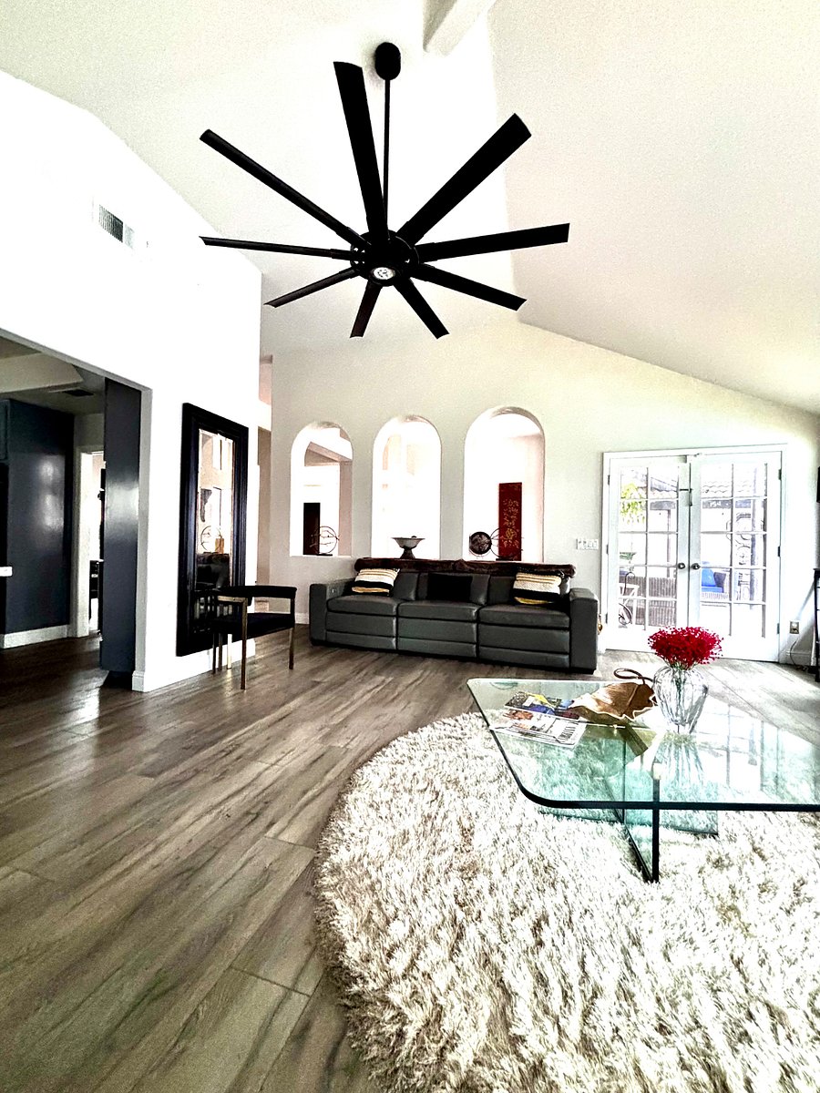 Living room with oversized windows looking out at patio