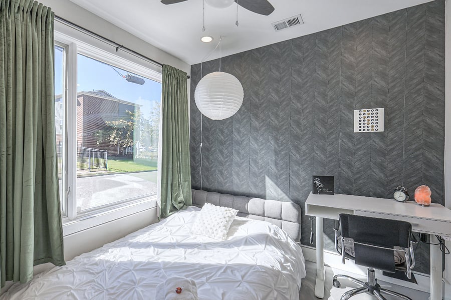 Peaceful bedroom with plush bedding and blackout curtains.