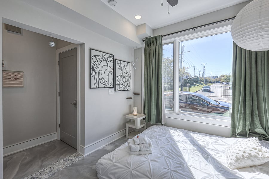 Peaceful bedroom with plush bedding and blackout curtains.