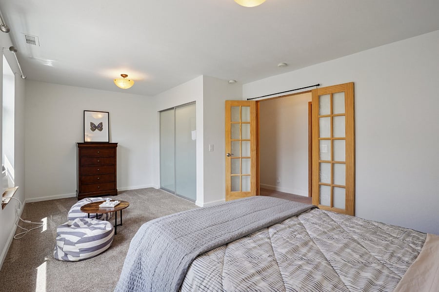 large bedroom now furnished with a desk and has a large closet