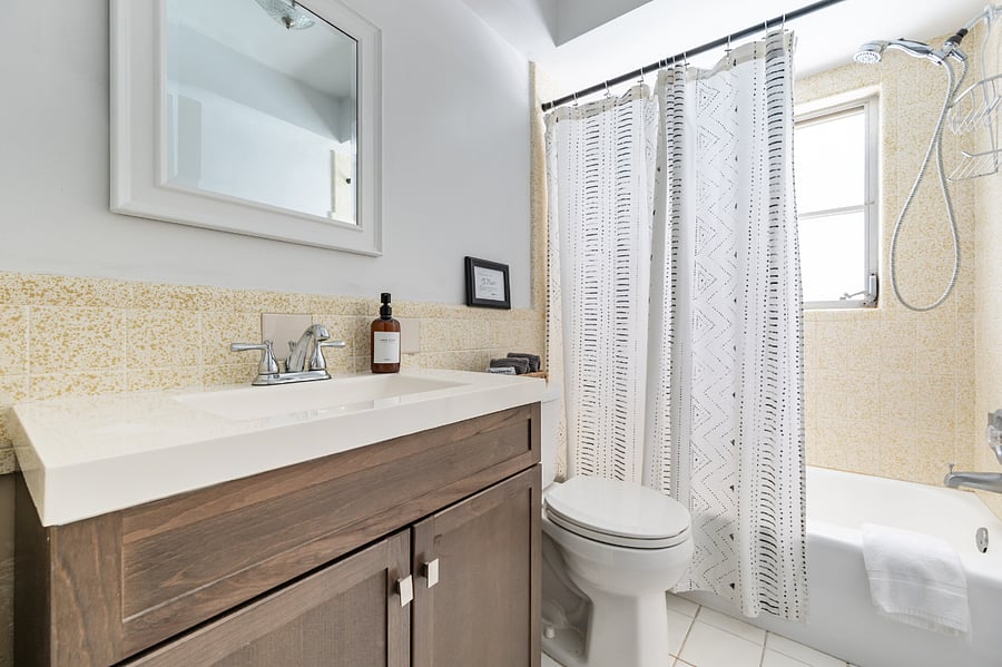 Hallway bathroom comes equipped with a tub.