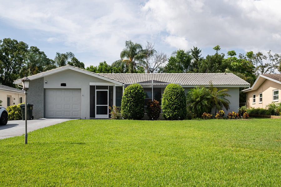 The front of the home featuring a large yard for outdoor activities.