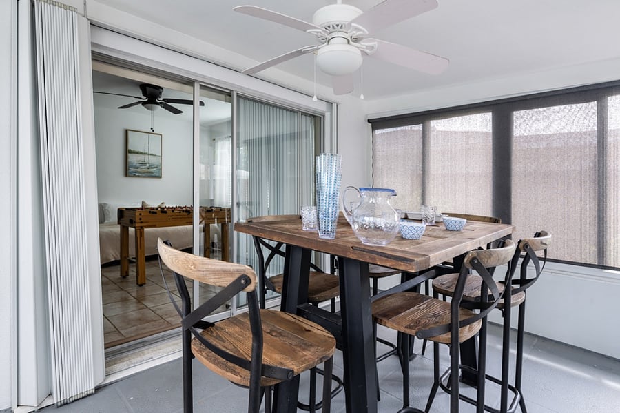 A glassed-in sunroom provides a secondary dining area for meals by the pool.