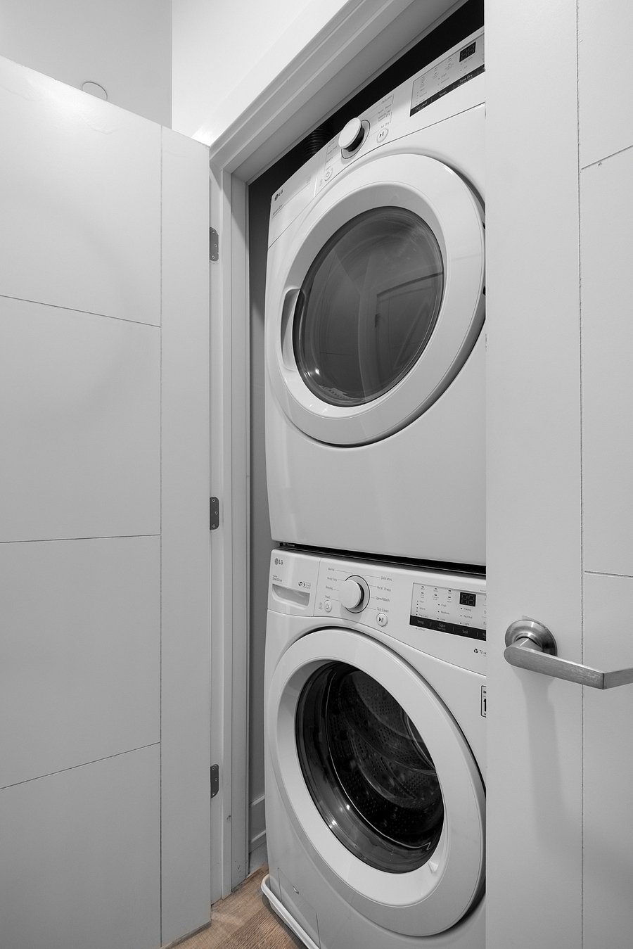 A stacked front-loading washer and dryer tucked neatly into a small closet.