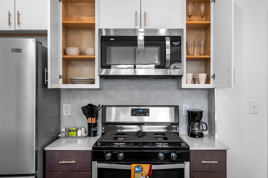 A sleek, modern kitchen with a white quartz island featuring a built-in sink.