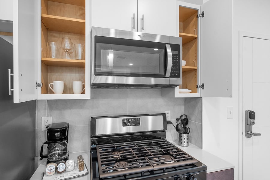 A sleek, modern kitchen with a white quartz island featuring a built-in sink.