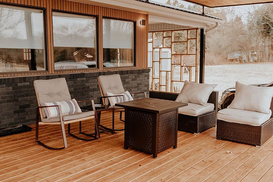 Front porch with seating and firepit with view of farm.