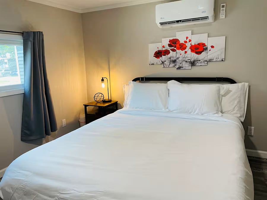 Comfortable queen bed with fresh linens and calming neutral tones