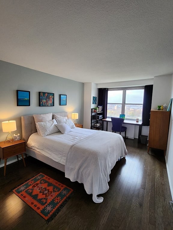 Quiet, cozy bedroom with queen bed, desk, and city views.