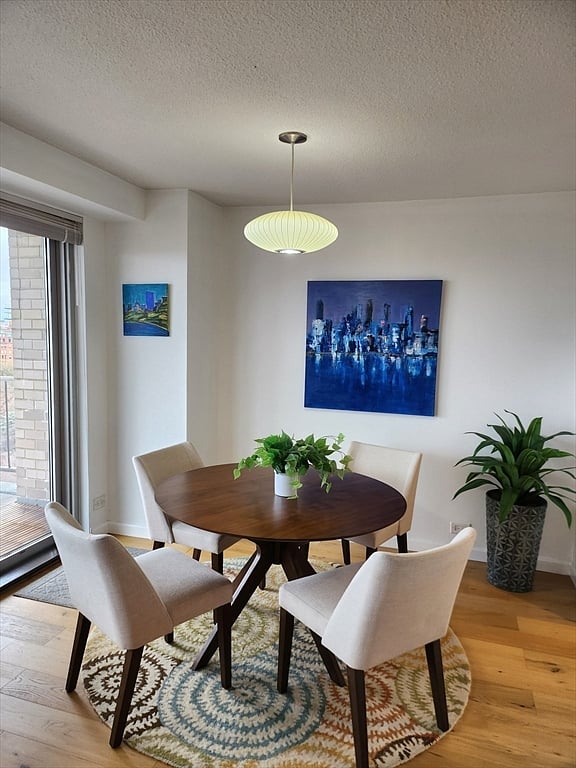 Bright dining area with seating for four and contemporary artwork.