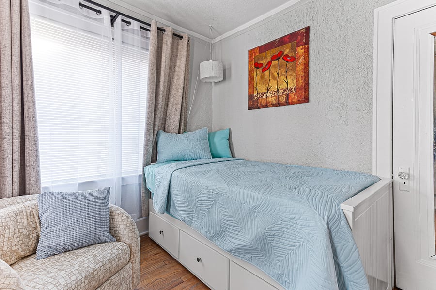 Apt. A Lower Flat Bedroom 1:  Flexible bedding arrangement.  Daybed converts to a king width bed. 3 large storage drawers under the bed.  Hardwood floors, closet, large mirror on closet door.  Large windows let in lots of natural light & great breezes to flow through the house.  
