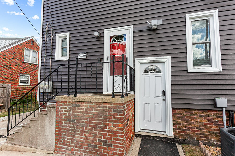 Red back door leads to a shared space entrance.  Once inside, the door to the left is the back entrance to the kitchen of Apt. A.  
At the top of the stairs is Apt. B.  This is the only entrance to the upper flat Apt. B.