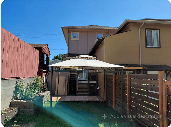 Fenced in backyard with lawn and Rose Planters