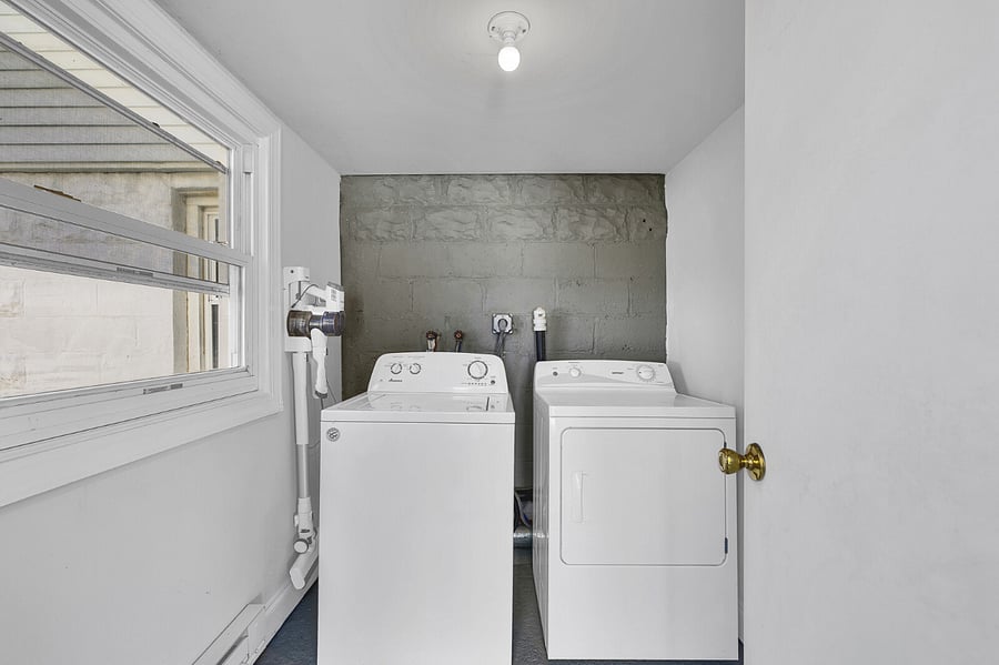 Laundry room w/vacuum, ironing board and iron.