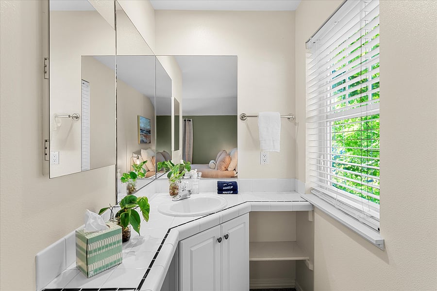 The second bedroom includes a private bathroom with separate vanity area perfect for getting ready while keeping the bath and toilet private.
