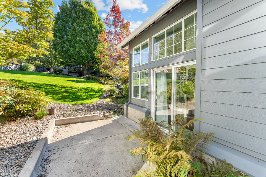 Sliding glass door opens to a small patio overlooking a spacious shared grassy area a peaceful spot for morning coffee or fresh air.