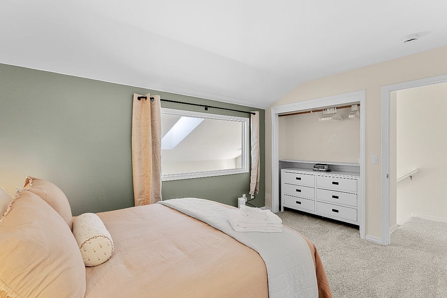 A large interior window brings in natural light from the living area below. Curtain provides privacy when desired.