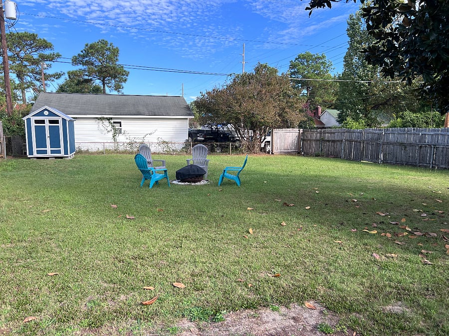 Fenced in backyard with fire pit.  