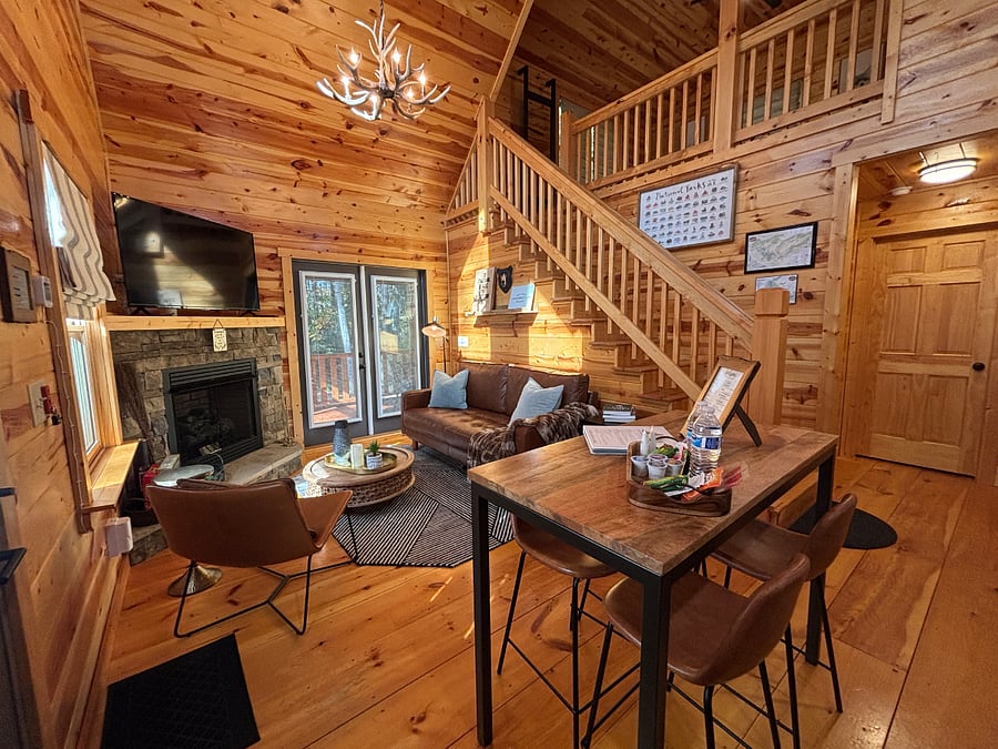 Open living and dining area with fireplace, Smart TV and patio access.