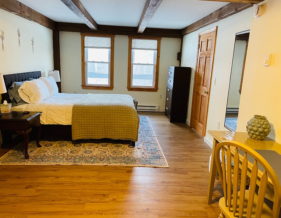 Large bedroom with queen bed and additional desk/workstation.