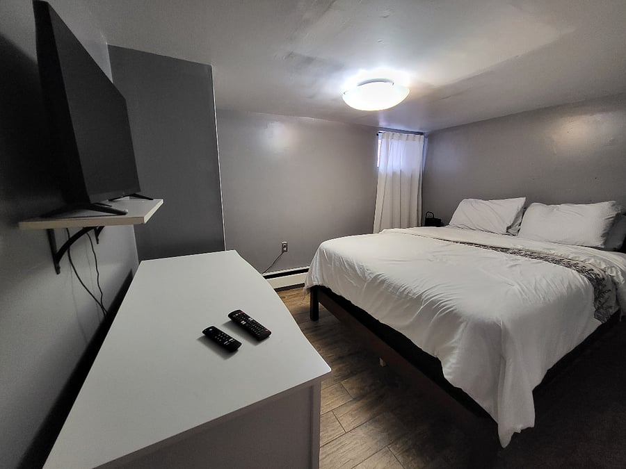 1st Bedroom with Queen size bed, dresser and smart tv.
