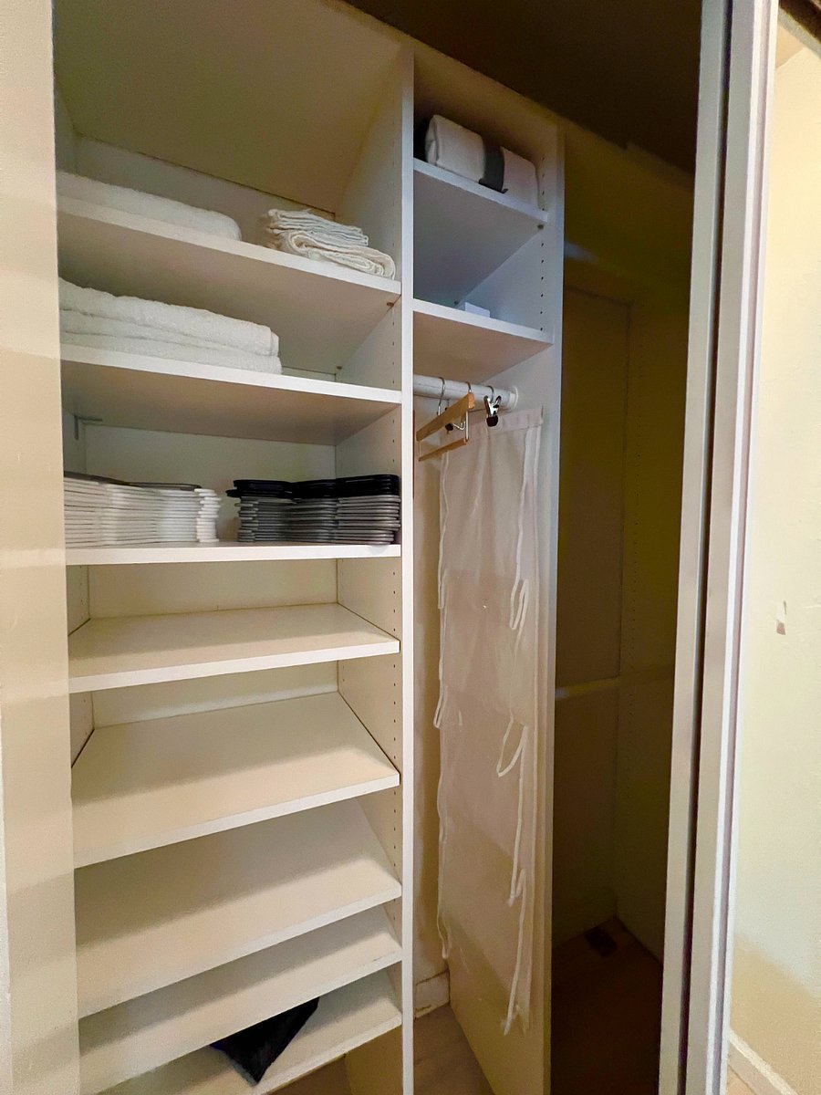 Mirrored closet with hangers and storage shoes/clothing rack 