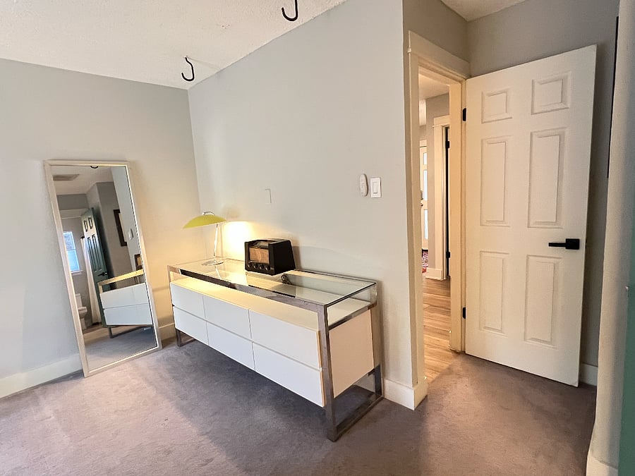 Entrance to the master bedroom is inset, view of dresser and full height mirror.