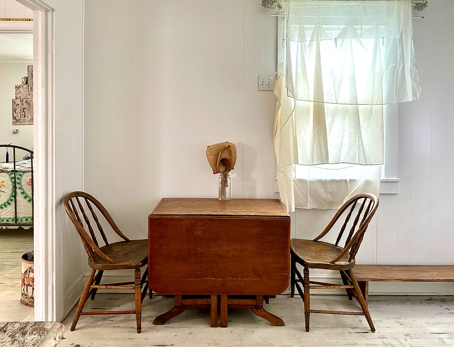 Kitchen has an antique gateleg ironing table. You can see into the bedroom.