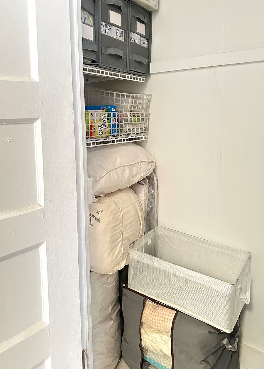 Linen closet on one side and cleaning items on the other side of this closet, located on the left side of the media armoire.