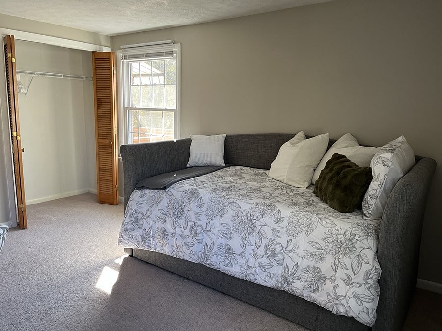Daybed with single twin mattress in guest room with workspace and workout equipment. Store things out of sight on the trundle below.
