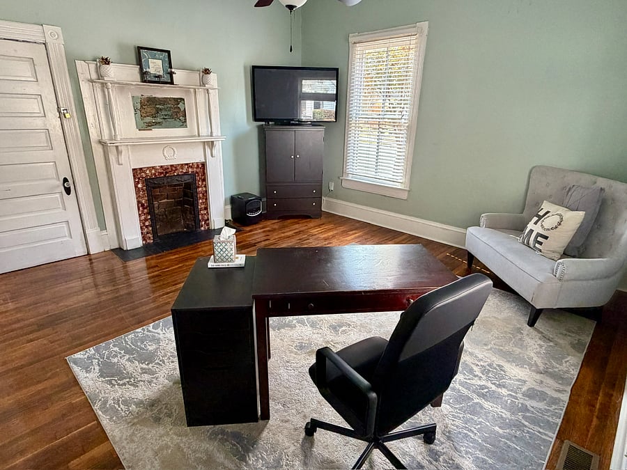 Office desk area with unusable vintage fireplace.