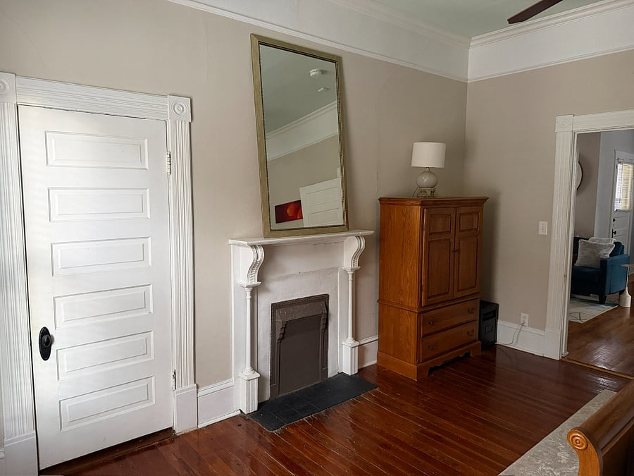 View of closet, unusable vintage fireplace, and linen cabinet.