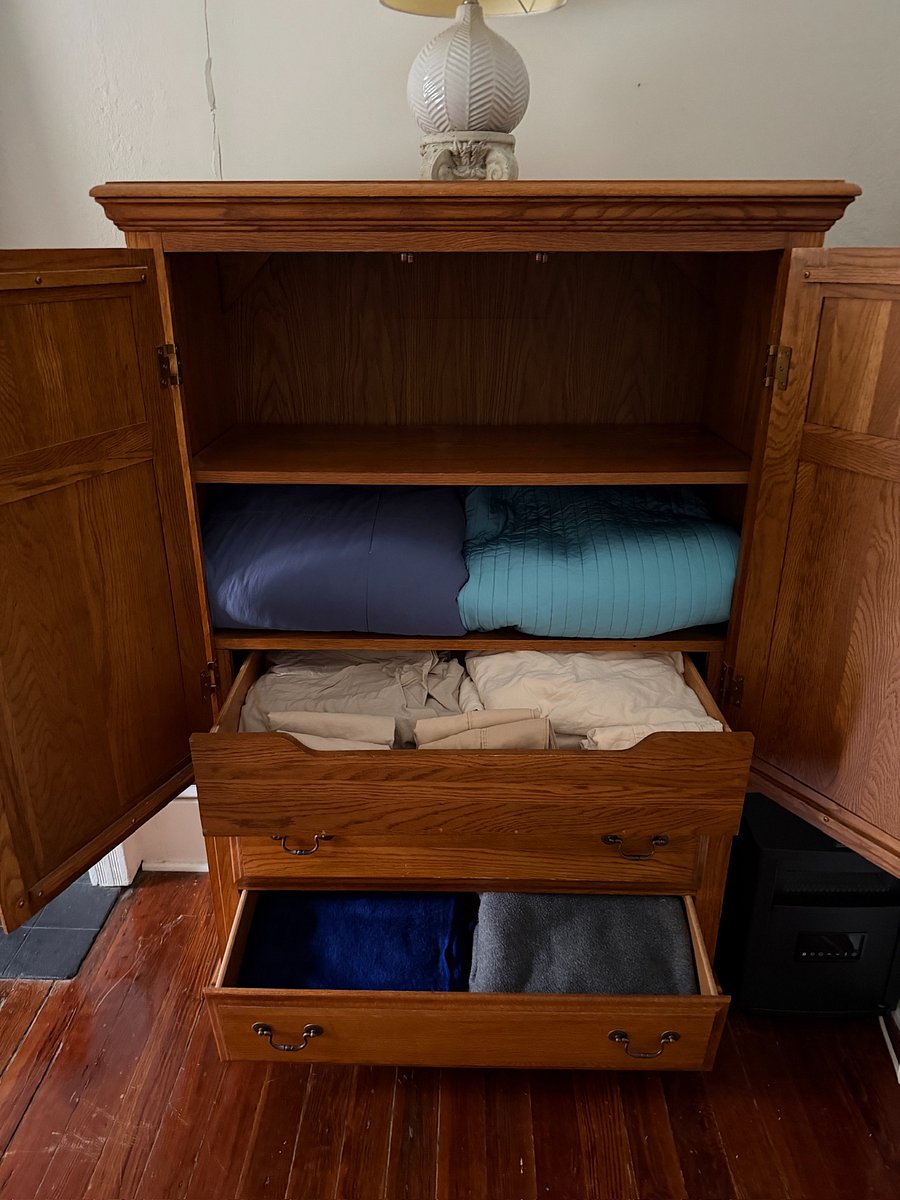 Spare bed linens in cabinet.