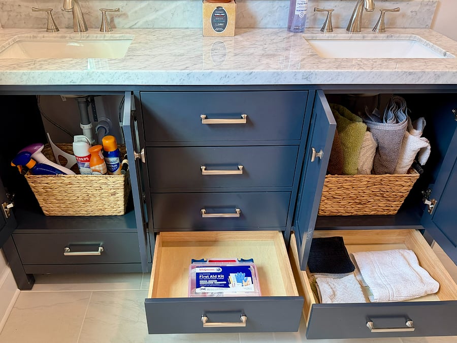 Newly renovated bathroom featuring storage space including sprays, towels, and first aid kit.