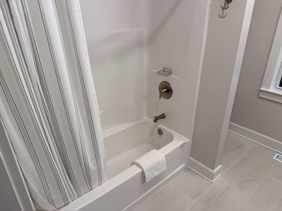 Newly renovated bathroom featuring bath and shower combo with floor towel.